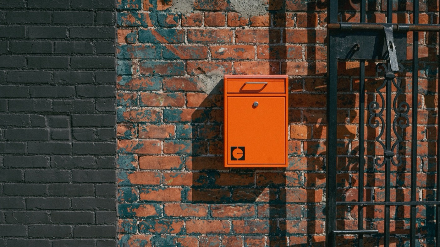 A Coffeehaus-orange mailbox mounted on the brick exterior of the Detroit roastery