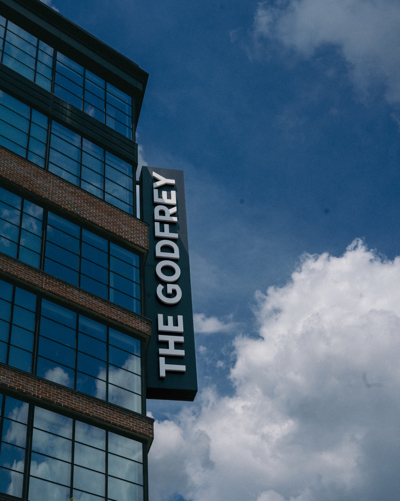 The Godfrey Hotel exterior signage against a bright Detroit sky