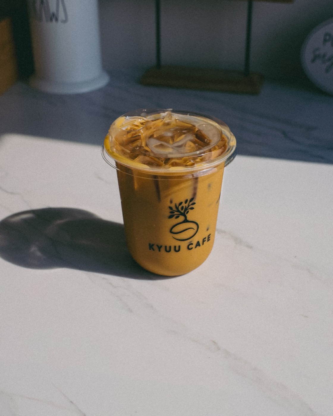 Finished iced brown butter brown sugar latte in a Kyuu Cafe cup