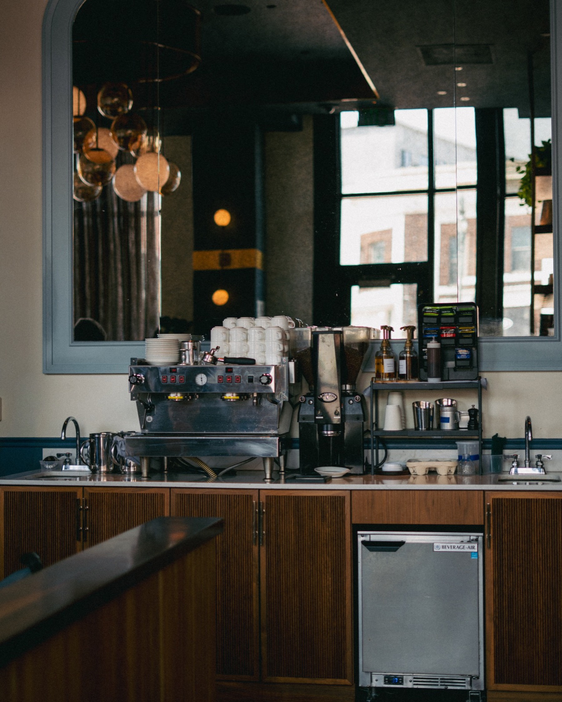 Espresso setup on a counter with grinder and cup stack