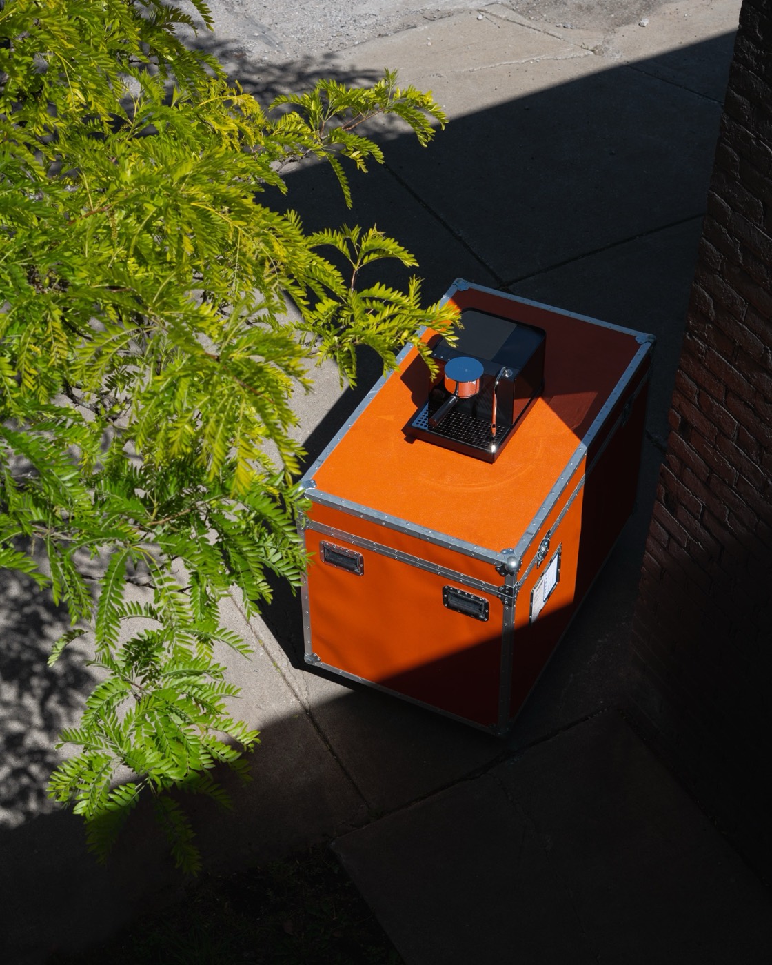 Fellow Espresso Series 1 sitting on its Coffeehaus-orange travel case