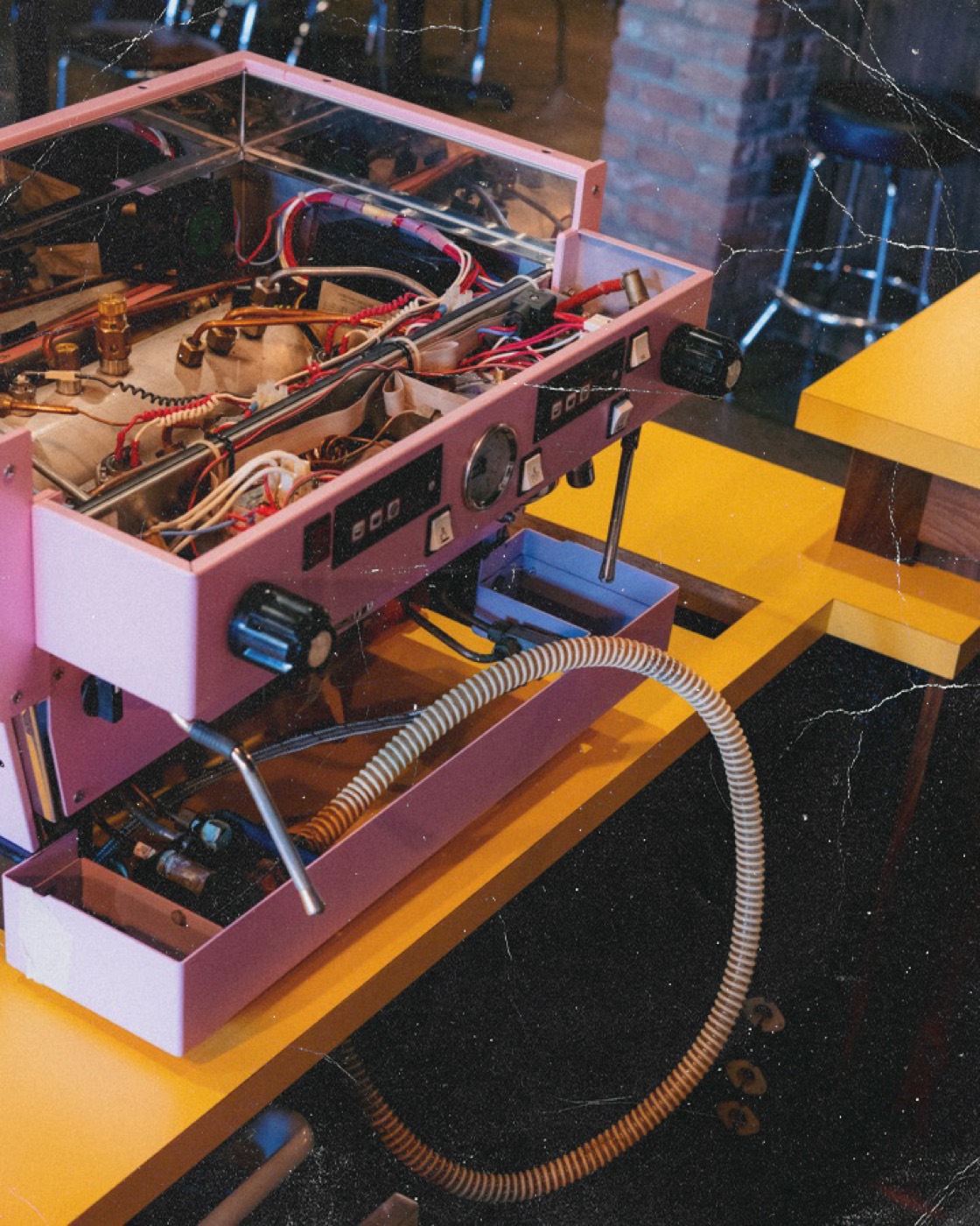 Pink espresso machine open for repair on a Coffeehaus service bench